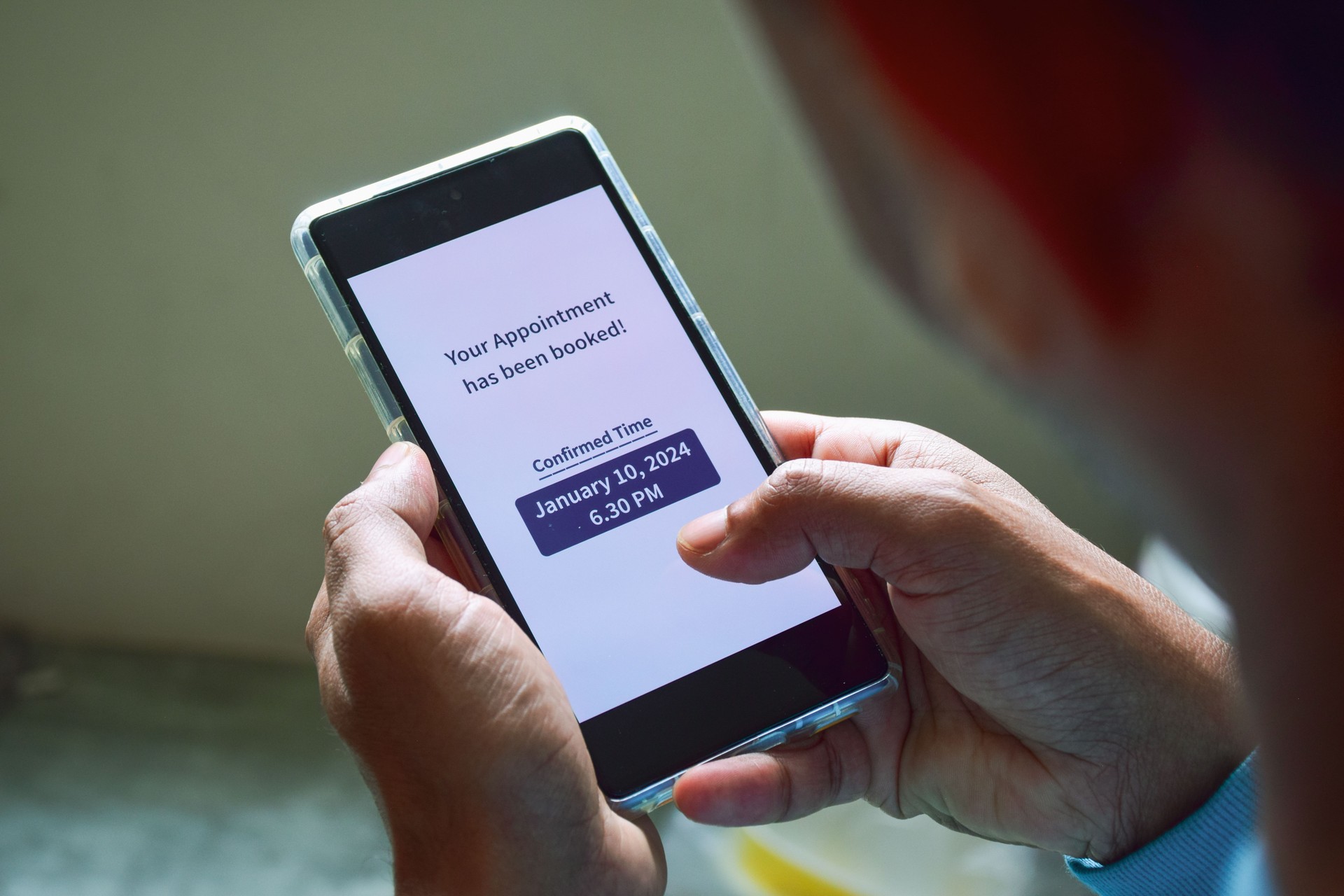 A South Asian man checking smartphone notification for his upcoming appointment. Online appointment booking and scheduling concept.